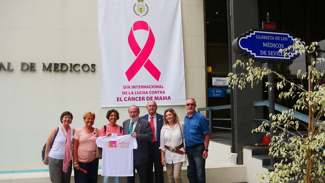 Una gran pancarta con el emblemático lazo rosa que simboliza la lucha contra el cáncer de mama en la fachada principal del Colegio de Médicos.