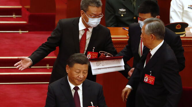 Xi Jinping (izqda.), sentado mientras obligan a salir a su predecesor, Hu Jintao