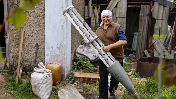 Una mujer muestra los restos de un cohete ruso, encontrado en su casa, después de que Ucrania haya recuperado este territorio.