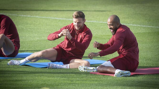 Rakitic y Marcao sonríen mientras estiran en el entrenamiento previo al Sevilla-Rayo Vallecano.