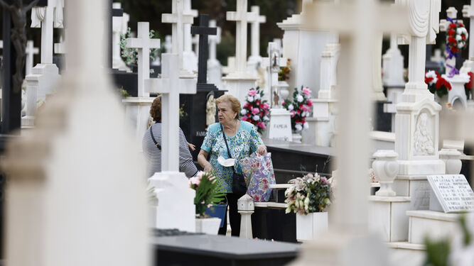 Dos mujeres se saludan en el cementerio de Sevilla en vísperas de Todos los Santos.