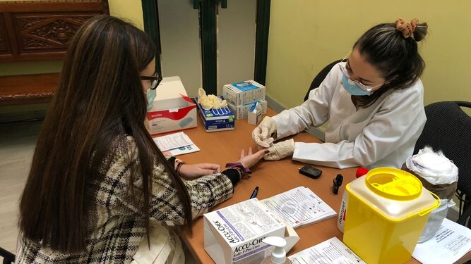 Una joven se somete al control de glucosa en el Colegio de Farmacéuticos de Sevilla durante la jornada divulgativa.