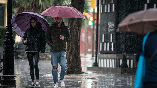 Jóvenes bajo la lluvia en Huelva.