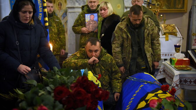 Familiares, amigos y compañeros asisten al funeral por tres soldados en Kiev.
