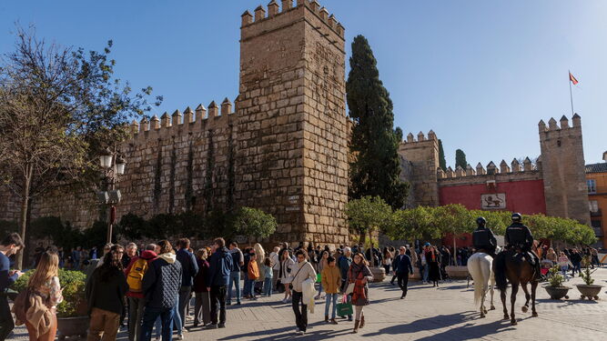 Una larga cola de turistas aguarda para acceder al Real Alcázar de Sevilla, sede del poder real en la ciudad.