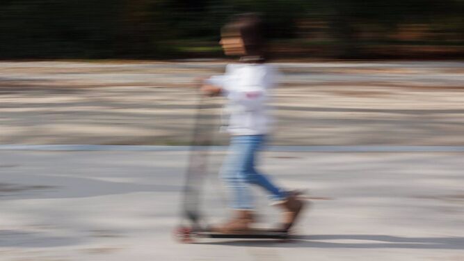 Una niña pasea con un patinete.
