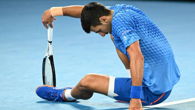 Djokovic en el suelo donde se le aprecia el aparatoso vendaje en su pierna izquierda.