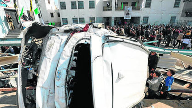Población local observa un vehículo destrozado a causa de la incursión militar israelí en Yenín (Cisjordania).