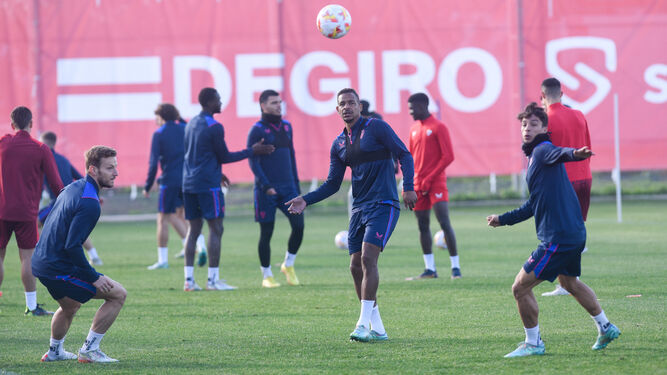 Fernando observa el balón en un rondo con Rakitic y Óliver Torres.