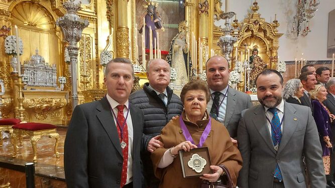 María del Carmen Puch Rodríguez-Caso con su familia al recoger el testimonio de gratitud de sus 75 años de hermana del Gran Poder.