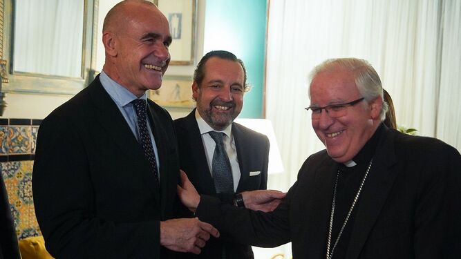 El alcalde y el arzobispo se ríen en presencia del pregonero.