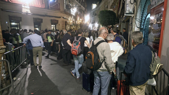 Turistas con mochilas contemplando al Cristo de la Conversión por la calle Arfe.