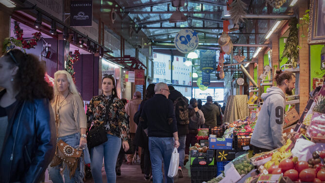 Consumidores comprando en un mercado de Sevilla.