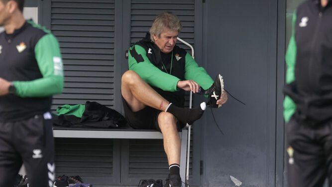 Pellegrini se calza las botas antes de un entrenamiento.