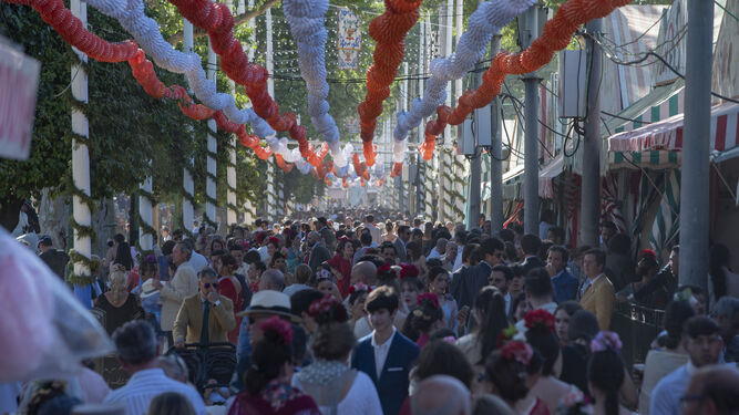 Una calle del real de la Feria, abarrotada de gente.