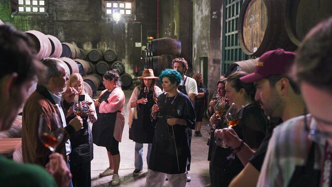 Los participantes del encuentro de 'bartenders' en Osborne siguen las explicaciones de la elaboración de brandy en El Tiro
