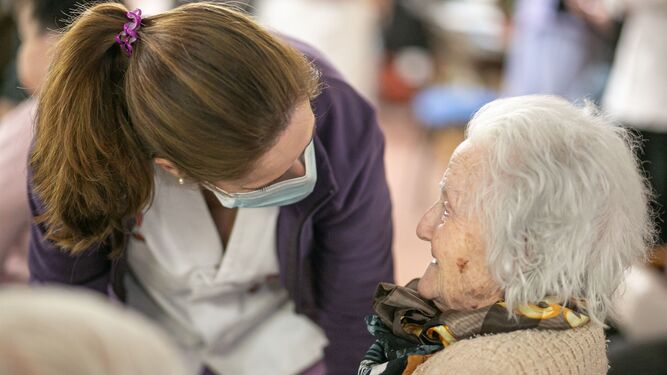 Una trabajadora asiste a una anciana.