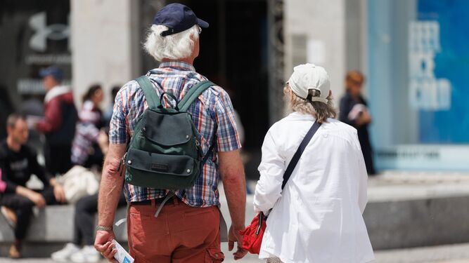 Dos turistas caminan por la Puerta del Sol de Madrid