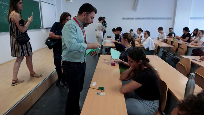 Un profesor reparte exámenes de Selectividad en la Universidad de Sevilla.