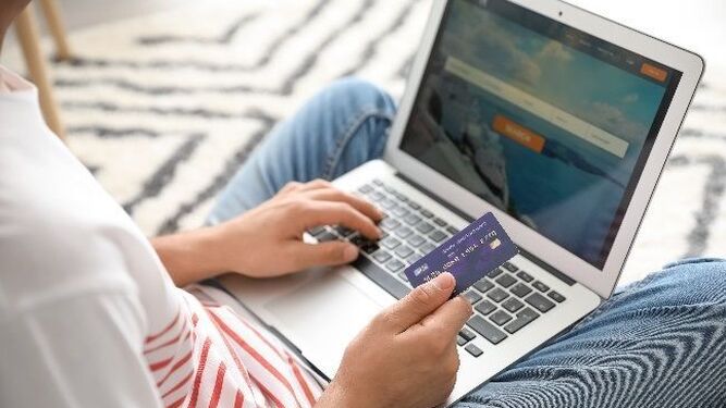 Un usuario utiliza una tarjeta de crédito desde un portátil.
