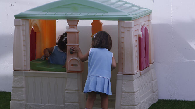 Dos niñas jugando en el patio de una guardería.