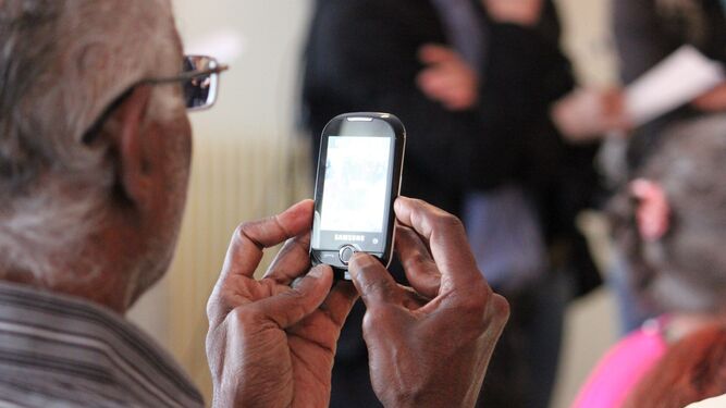 Una persona mayor utiliza su dispositivo móvil.