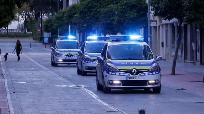 Patrulleros de la Policía Local pasan por una calle de Sevilla casi vacía en pleno confinamiento, cuando ocurrieron los hechos.