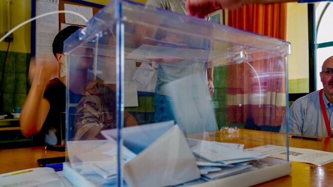 Una persona deposita su voto en una urna