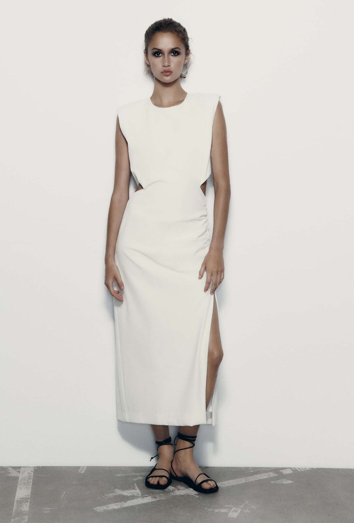 La modelo con un vestido blanco lleva un vestido largo blanco con una falda  larga.