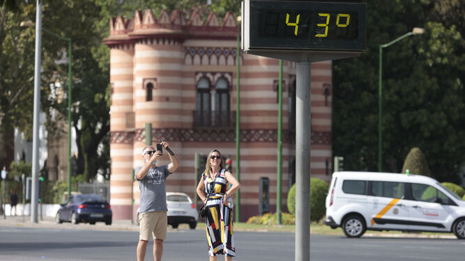 Dos turistas fotografían un termómetro en Sevilla con 43 grados.