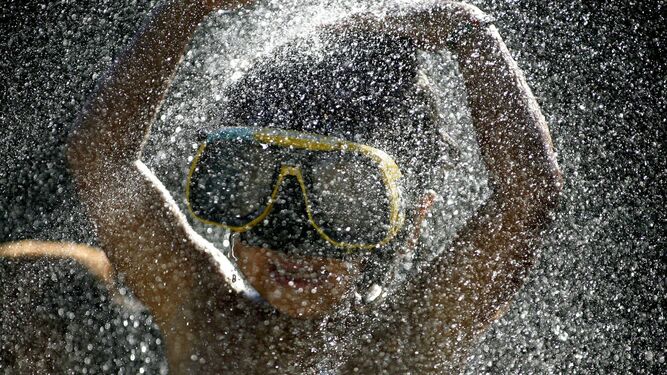 Un niño con gafas de bucear en una piscina.