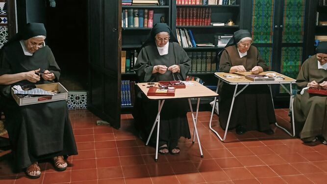 Varias religiosas de Las Teresas confeccionan los escapularios carmelitas en la hora de la recreación.