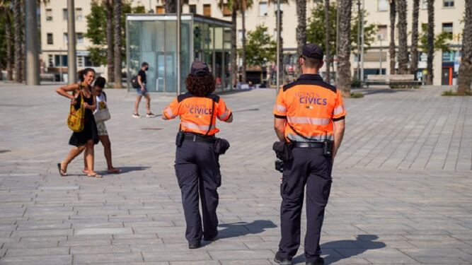 Dos agentes cívicos patrullan a pie las calles de Barcelona.