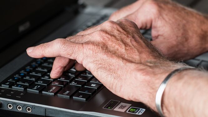 Persona mayor con un ordenador portátil.