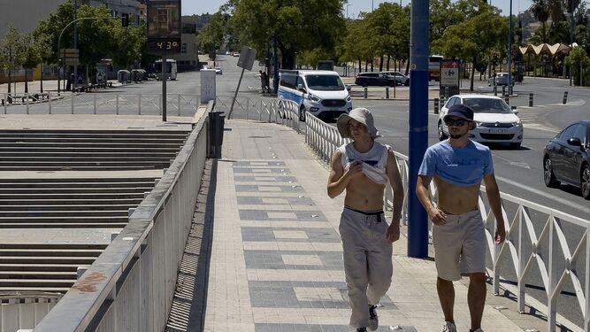 Dos jóvenes soportan los 43 grados que marca el termómetro en Sevilla.
