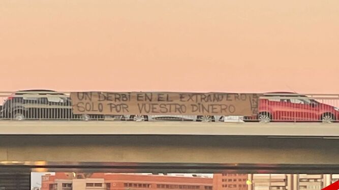 Pancarta en una pasarela en una de las vías de tráfico rodado de Sevilla.