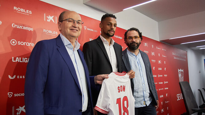 Djibril Sow posa con la camiseta del Sevilla entre José Castro y Víctor Orta.