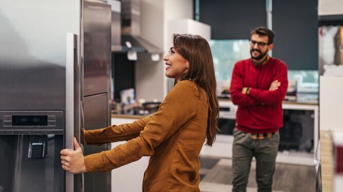 Una pareja revisa frigoríficos durante su proceso de compra