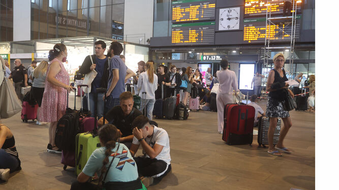 Varios viajeros esperan la salida de su tren en la estación de Santa Justa en Sevilla