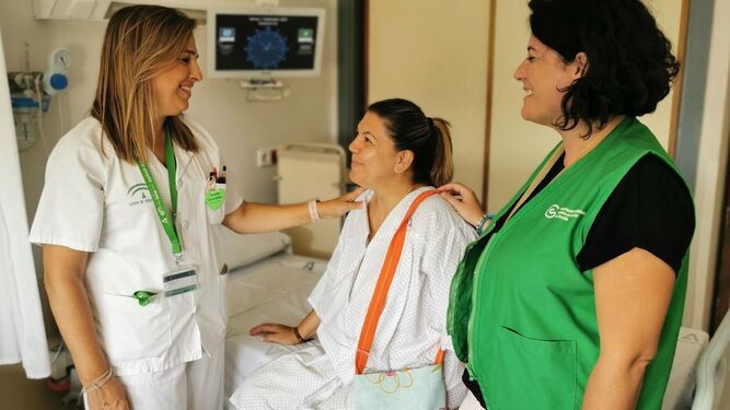 Paciente de la planta de Ginecología con bolsa con drenaje acompañada de la supervisora de enfermería Amelia Gallego y la coordinadora del Voluntariado de la AECC en el Valme, Rocío del Pilar Grima.