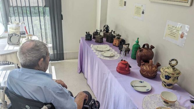 Uno de los usuarios de la residencia Gerón Sevilla contempla algunos de los objetos expuestos.