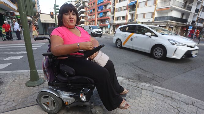 La sevillana Sol Duque Puig en su silla de ruedas en una calle del barrio de Los Remedios.