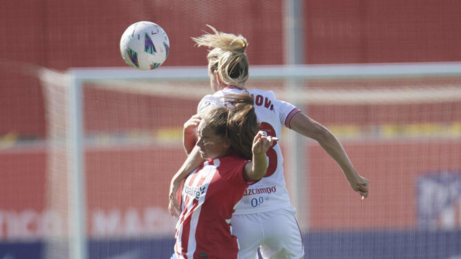 Cahynová salta con una jugadora del Atlético de Madrid.
