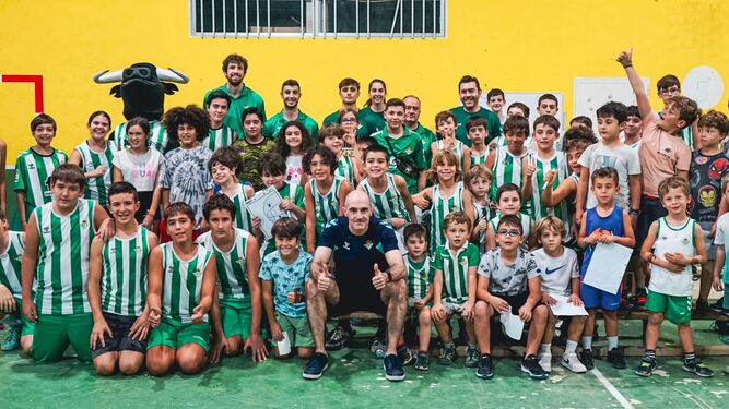 Javi Carrasco, rodeado de niños en una visita de jugadores y del club al colegio Aljarafe.