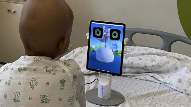 Un menor hospitalizado mira la app del Robot Haru, que se presentará en la gala.
