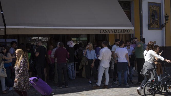 Varios clientes beben en el exterior de Casa Vizcaíno, en la céntrica calle Feria.