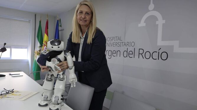 El robot humanoide, Curro, junto a la presidenta de la Asociación ETC, durante la rueda de prensa, en el Virgen del Rocío.