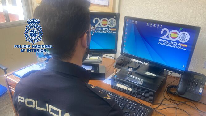 Un policía nacional consulta un ordenador.