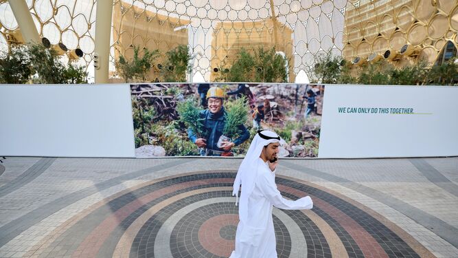 Un hombre camina por Expo City Dubai, donde tendrá lugar la Cumbre del Clima.