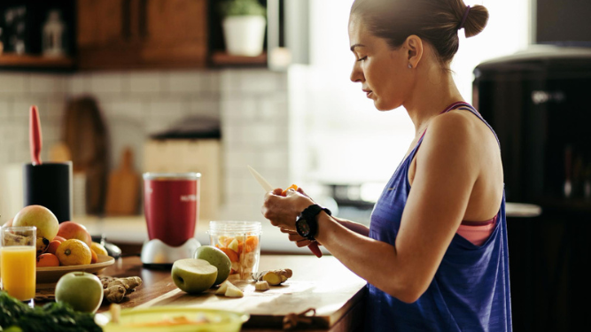 Mujer preparando comida saludable después de hacer ejercicio.